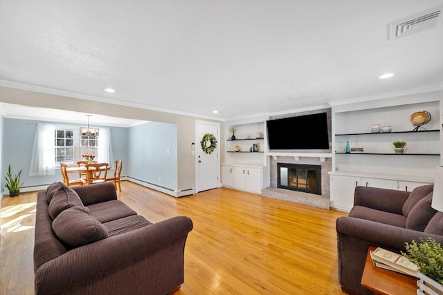 living room featuring crown molding, a baseboard radiator, built in shelves, and light wood-type flooring