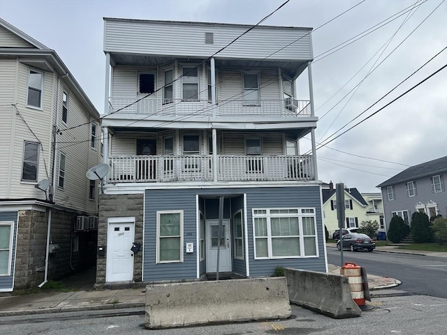 townhome / multi-family property with a balcony and stone siding