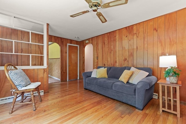 133 Allen Rd, Easton, MA 02356 - living room featuring arched walkways, hardwood / wood-style floors, a ceiling fan, wood walls, and a baseboard heating unit