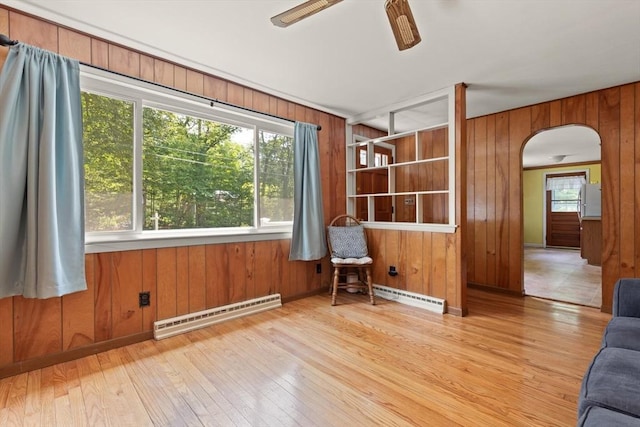 133 Allen Rd, Easton, MA 02356 - unfurnished room featuring a baseboard radiator, wooden walls, hardwood / wood-style floors, arched walkways, and a ceiling fan