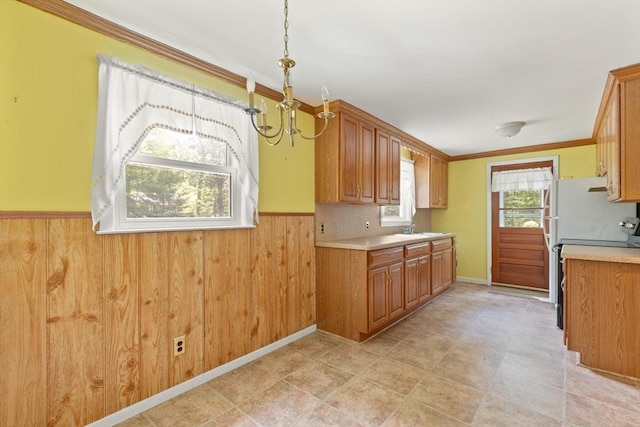 133 Allen Rd, Easton, MA 02356 - kitchen featuring a chandelier, wainscoting, light countertops, brown cabinets, and crown molding