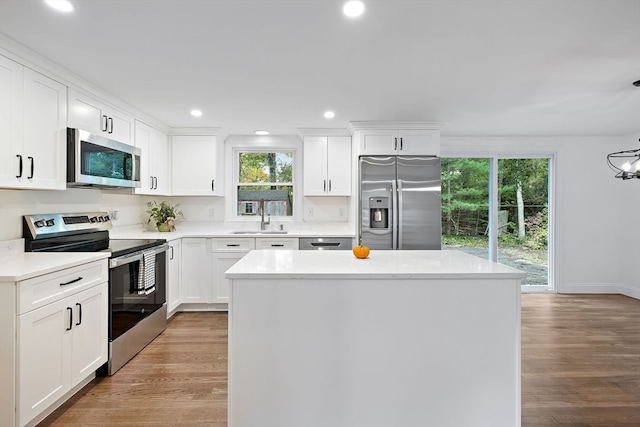 kitchen with white cabinets, stainless steel appliances, and light wood-type flooring