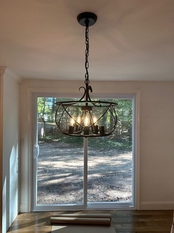 details with an inviting chandelier and hardwood / wood-style floors