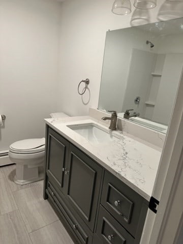 bathroom featuring vanity, toilet, and a shower