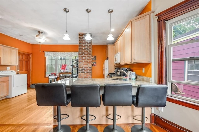 71 Draper St, Boston, MA 02122 - kitchen featuring washer / dryer, white appliances, a peninsula, and light brown cabinets