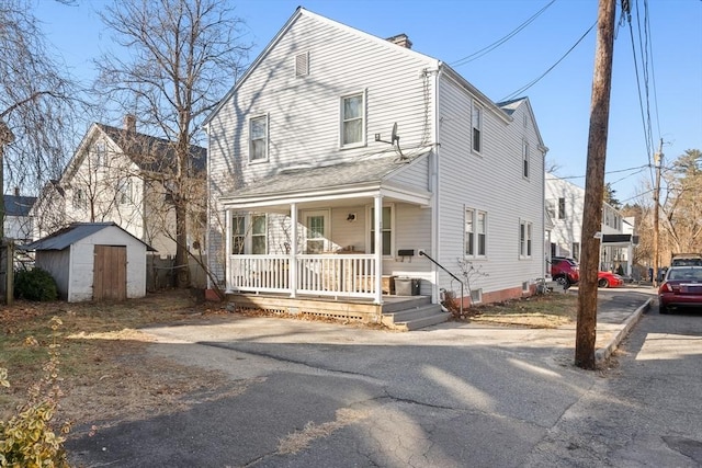 view of front property featuring a shed and a porch