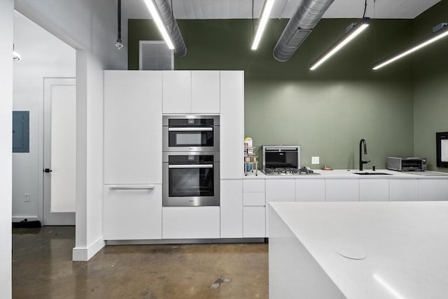 437 D St Unit 3D, Boston, MA 02210 - kitchen featuring electric panel, a sink, concrete floors, white cabinets, and modern cabinets