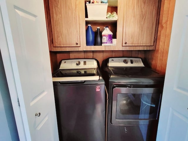 washroom with independent washer and dryer and cabinet space