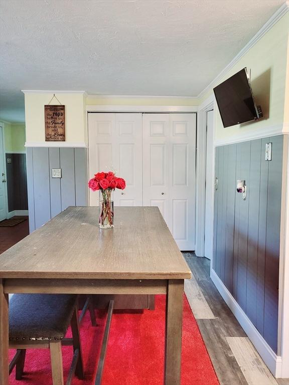 dining room with dark wood-type flooring and ornamental molding
