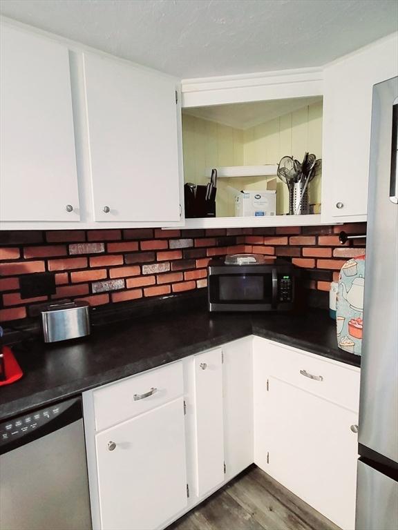 kitchen featuring appliances with stainless steel finishes, backsplash, and dark countertops