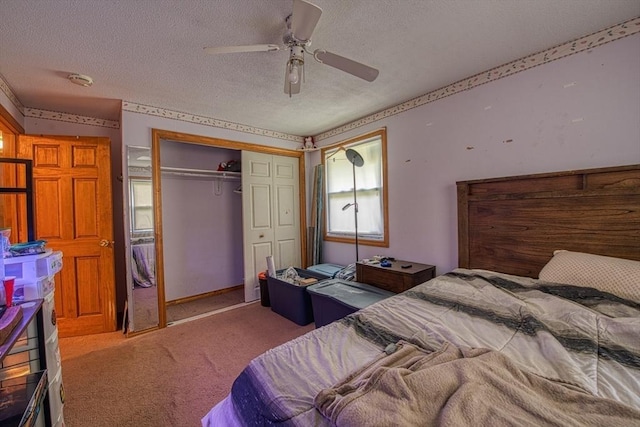 carpeted bedroom with a textured ceiling, a closet, and a ceiling fan