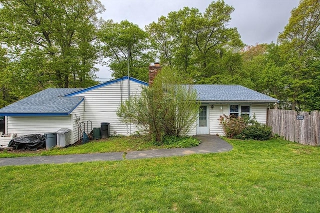 view of front of house featuring a chimney and a shingled roof