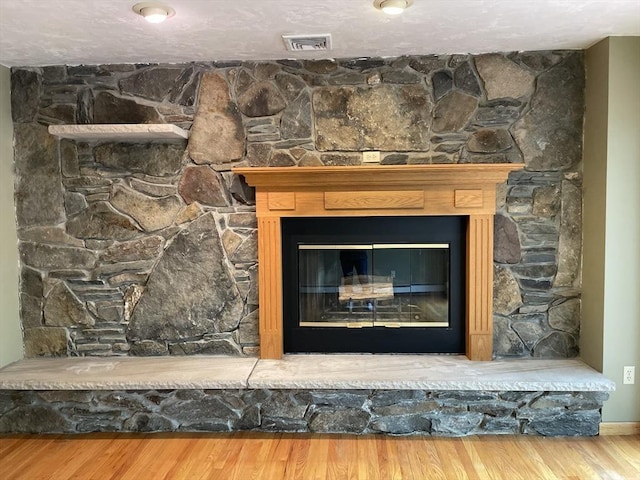 interior details with hardwood / wood-style flooring and a stone fireplace