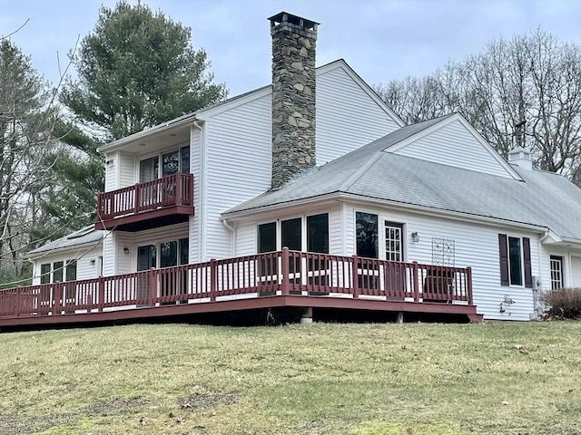 rear view of property with a yard and a deck