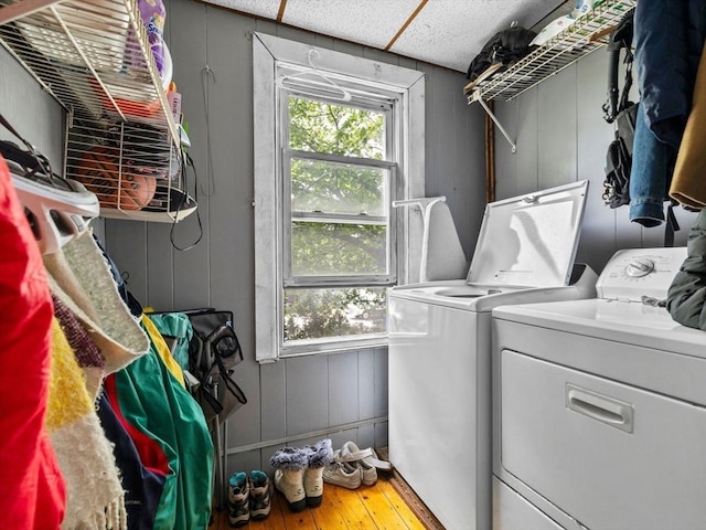 19 Tufts St, Somerville, MA 02145 - laundry area featuring washing machine and clothes dryer, hardwood / wood-style floors, and a decorative wall