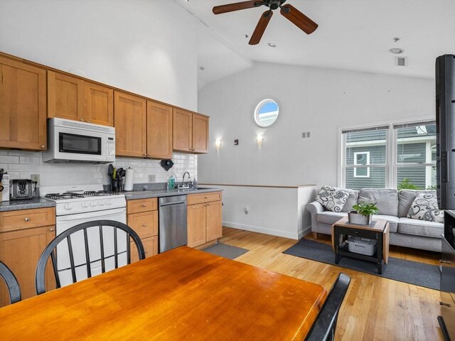 19 Tufts St, Somerville, MA 02145 - kitchen featuring white appliances, backsplash, ceiling fan, light wood-type flooring, and high vaulted ceiling