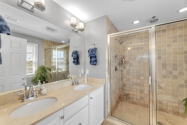full bathroom with a stall shower, recessed lighting, and double vanity