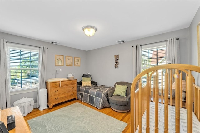 bedroom featuring multiple windows and wood finished floors