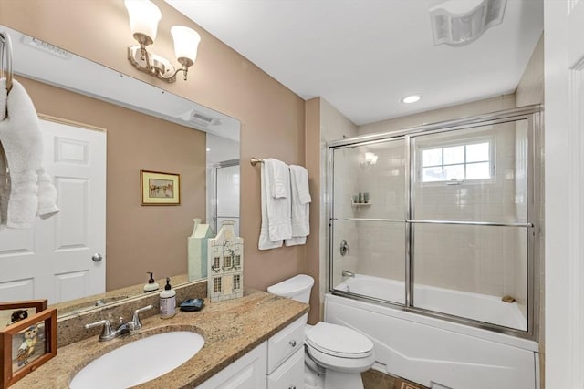 full bath featuring toilet, vanity, and bath / shower combo with glass door