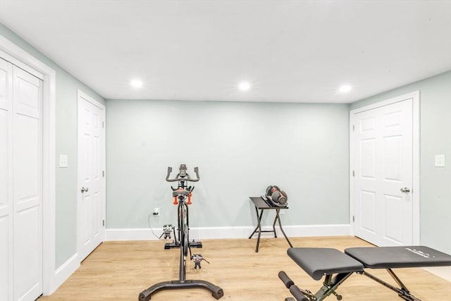 exercise area featuring light wood-type flooring, recessed lighting, and baseboards