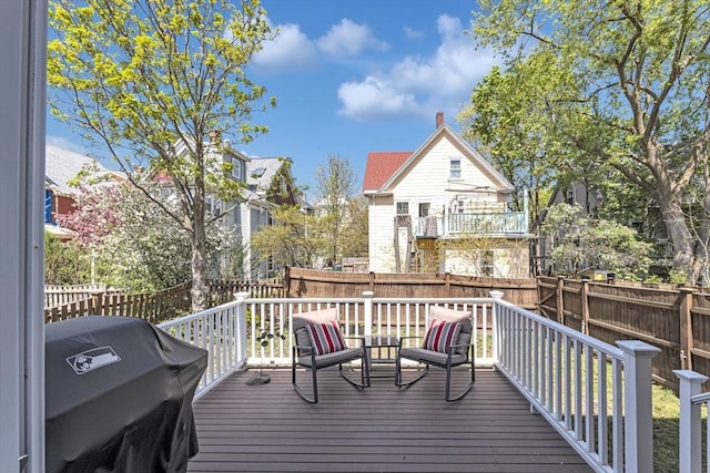 deck with area for grilling and a fenced backyard