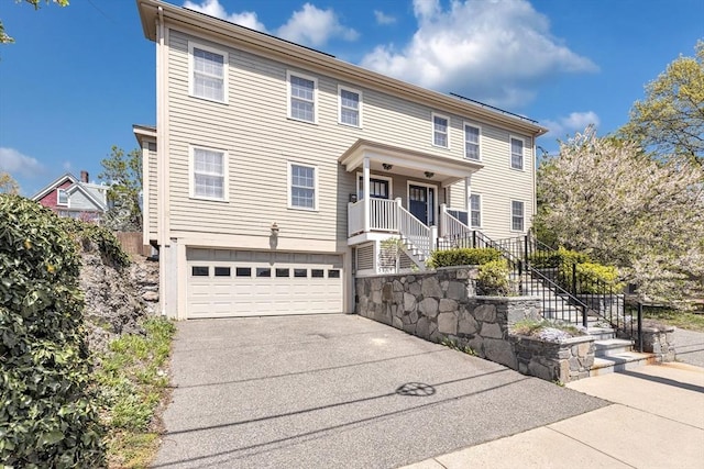 view of front of property featuring stairs, an attached garage, and concrete driveway
