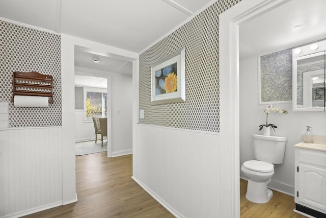 63 Adams St, Bourne, MA 02532 - bathroom with vanity, toilet, wood finished floors, and a wainscoted wall