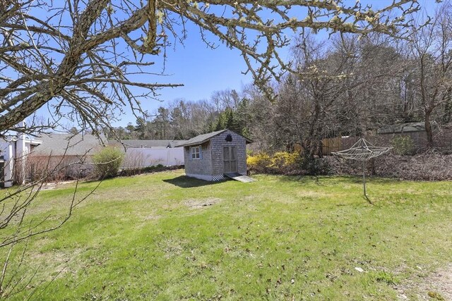 63 Adams St, Bourne, MA 02532 - view of yard featuring an outdoor structure, a fenced backyard, and a shed