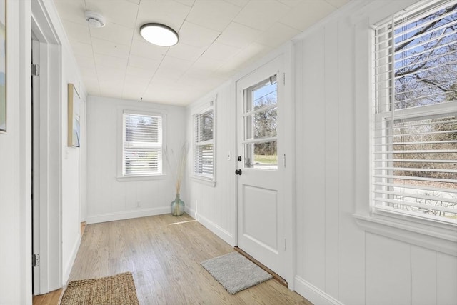 63 Adams St, Bourne, MA 02532 - doorway with baseboards, light wood finished floors, and a decorative wall