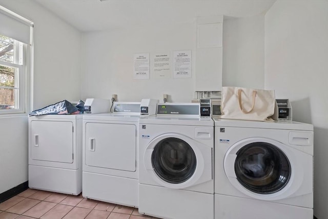 common laundry area with light tile patterned floors, independent washer and dryer, and baseboards