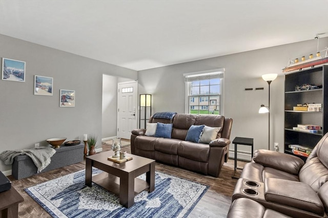 living room featuring a baseboard heating unit, baseboards, and wood finished floors