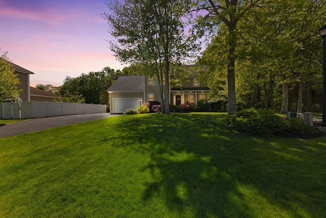 view of yard with asphalt driveway and a garage