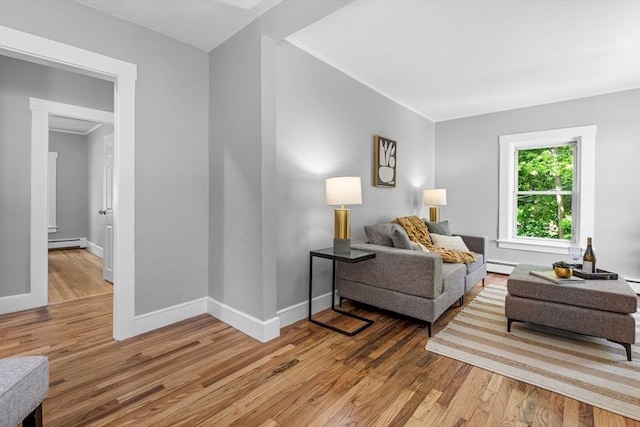 living room featuring baseboard heating, light wood-style flooring, baseboards, and a baseboard radiator