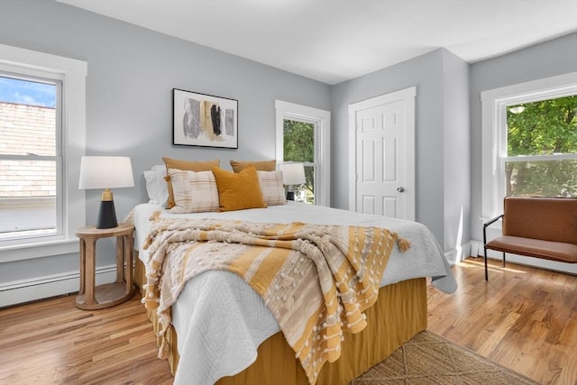 bedroom featuring multiple windows and wood finished floors