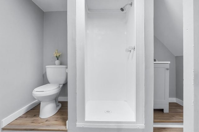 bathroom featuring a shower stall, baseboards, toilet, and wood finished floors