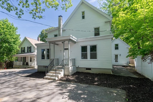 view of front of house featuring a chimney and fence