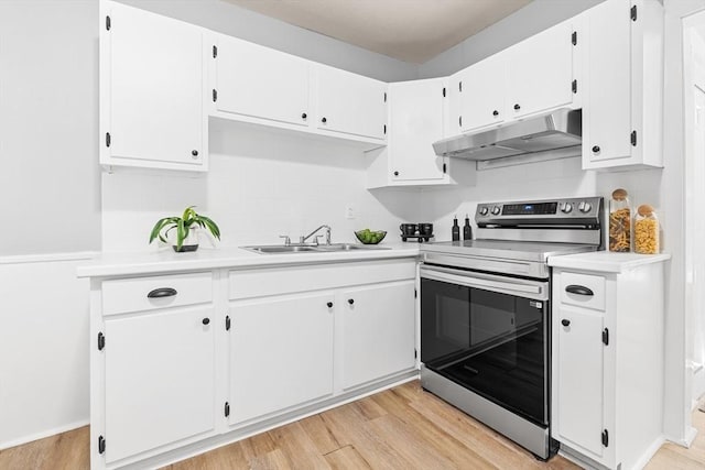 kitchen with stainless steel electric range oven, under cabinet range hood, a sink, light countertops, and light wood finished floors
