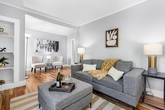living room with wood finished floors, built in features, and baseboards