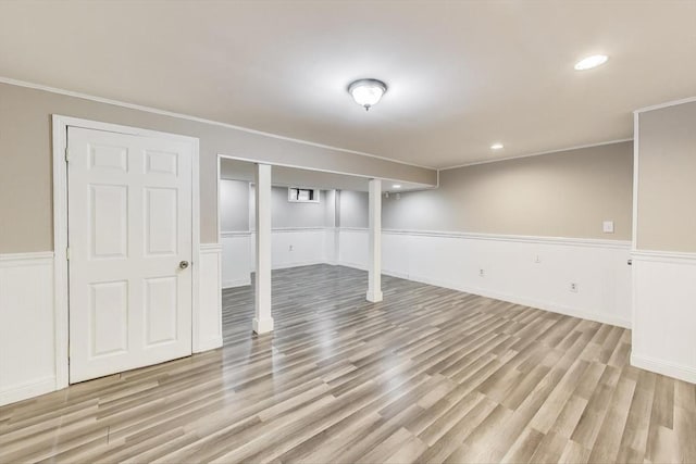 basement featuring crown molding and light hardwood / wood-style floors