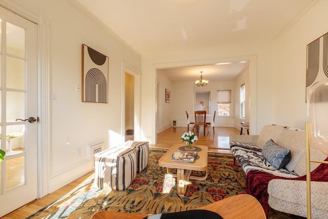 living room with a chandelier and light hardwood / wood-style flooring