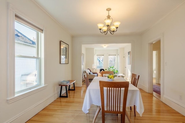 dining room with a notable chandelier, light hardwood / wood-style floors, and ornamental molding