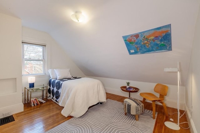 bedroom featuring hardwood / wood-style floors and lofted ceiling