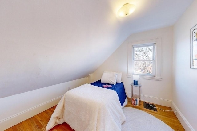 bedroom featuring hardwood / wood-style floors and lofted ceiling