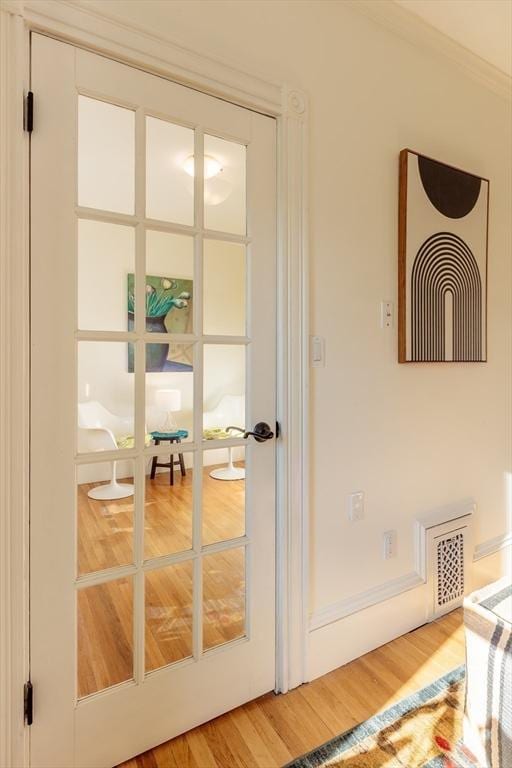 doorway with hardwood / wood-style flooring and ornamental molding