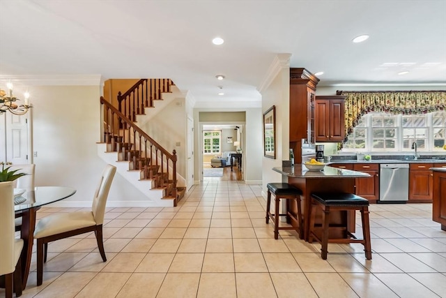 20 Hillery Rd, Leominster, MA 01453 - kitchen with stainless steel dishwasher, ornamental molding, dark countertops, a kitchen bar, and light tile patterned floors