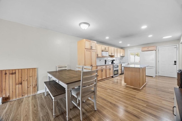 dining room with recessed lighting, light wood-style floors, and baseboards