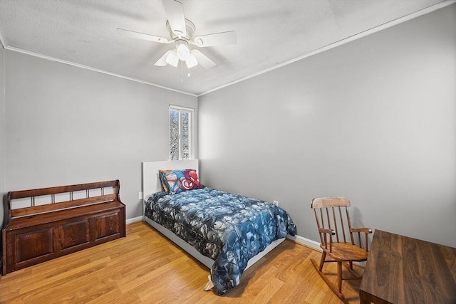 bedroom with ceiling fan, wood finished floors, baseboards, and ornamental molding