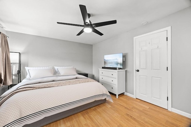 bedroom featuring baseboards, light wood-type flooring, and ceiling fan