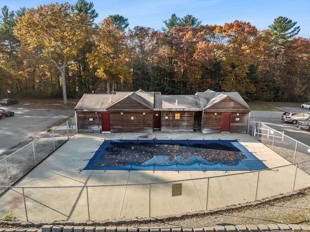 community pool with a patio area and fence