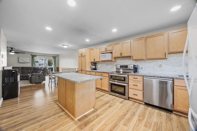 kitchen featuring appliances with stainless steel finishes, light brown cabinetry, and light wood finished floors